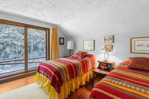 a bedroom with two beds and a large window at Smugglers Trove a Mountain Adventure Getaway in Cambridge +15 photos