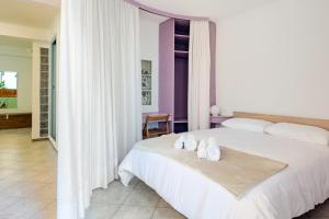 a bedroom with a white bed with towels on it at Stylish & Colorful Open Space - Sleeps 5 in Manarola