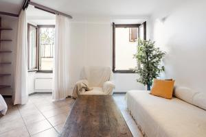 a living room with a couch and a chair and windows at Stylish & Colorful Open Space - Sleeps 5 in Manarola