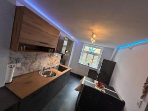 a kitchen with a sink and a counter with blue lights at RosaVilla in Wilhelmshaven