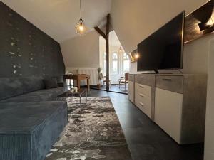 a living room with a couch and a flat screen tv at RosaVilla in Wilhelmshaven