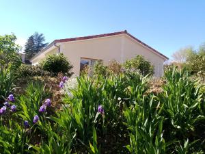 a house with purple flowers in front of it at domaine de marodi jasmin in Baignes-Sainte-Radegonde