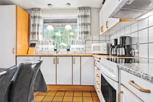 a kitchen with white cabinets and a window at 0315-Romo-Dyssebjergvej-49 in Høm +17 photos