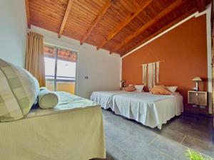a bedroom with two beds and a large window at Pensao Porta do Vento in Santa Maria