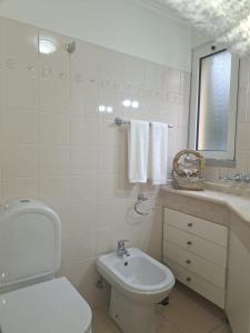 a white bathroom with a toilet and a sink at Paradise Valley Ponta do Sol in Ponta do Sol +35 photos