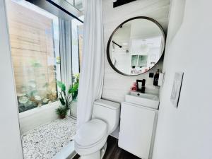 a bathroom with a toilet and a mirror at Walk to Siesta Key Beach-Remote Worker Friendly -High Speed WiFi- Bikes Included -Private Fenced In -Close to Restaurants, Coffee Houses & Shops - Paisleys Keep it Simple Casita in Siesta Key