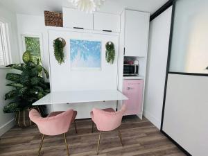 a kitchen with pink chairs and a white refrigerator at Walk to Siesta Key Beach-Remote Worker Friendly -High Speed WiFi- Bikes Included -Private Fenced In -Close to Restaurants, Coffee Houses & Shops - Paisleys Keep it Simple Casita in Siesta Key