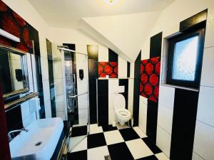 a bathroom with a black and white checkered floor at Imperial Resort in Codlea +43 photos