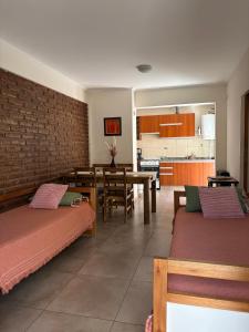 a room with two beds and a table and a kitchen at Complejo Pampa 1 in Santa Rosa