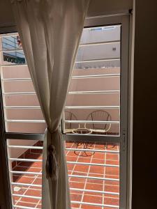 a window with a curtain in front of a door at Complejo Pampa 1 in Santa Rosa