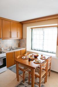 a kitchen with a wooden table and chairs and a sink at Το Αρχοντικό της Λενιώς in Taxiárkhis