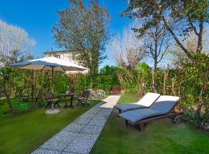 a patio with an umbrella and a table and chairs at B&B Borgo di Pratavecchie in Migliarino