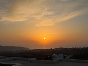 a sunset over a city with the sun in the sky at Evira Suites in Pyrgos +26 photos