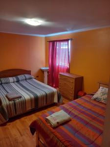 a bedroom with two beds and a dresser and a window at HOSTAL LA CASONA ALFREDO CAMPOS in Ovalle
