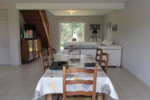 a dining room with a table and chairs and a kitchen at Maison moderne Le doux refuge des pêcheurs près de la mer à Cancale 3 étoiles in Cancale