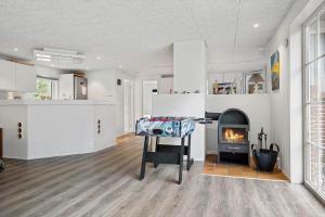 a living room with a fireplace and a table at 0119-Romo-Smafolksvej-43 in Høm