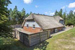 a house with a thatched roof and a yard at 0119-Romo-Smafolksvej-43 in Høm