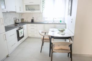 a kitchen with a table and chairs and a sink at Noméa - Modern Apartment Aigio in Aigio