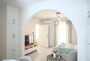 a white living room with a bed and a tv at Noméa - Modern Apartment Aigio in Aigio