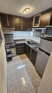 a kitchen with stainless steel appliances and brown cabinets at Dúplex Premium Cañada!! in Cañada de Gómez