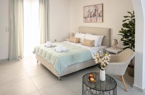 a bedroom with a large bed and a chair at Noméa - Modern Apartment Aigio in Aigio