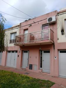 a pink building with doors and a balcony at Dúplex Premium Cañada!! in Cañada de Gómez