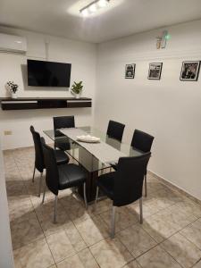 a dining room with a glass table and black chairs at Dúplex Premium Cañada!! in Cañada de Gómez