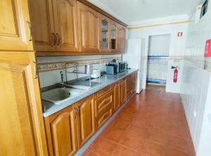 a kitchen with wooden cabinets and a sink at Mouraria in Elvas