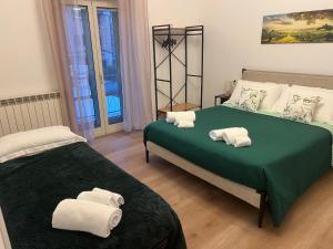 a bedroom with two beds with towels on them at Le Camere di Don Nicó in Tarquinia +7 photos