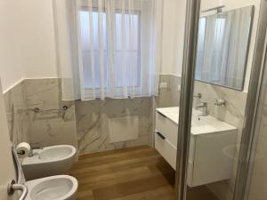 a white bathroom with a sink and a toilet at Le Camere di Don Nicó in Tarquinia