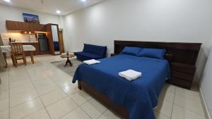a bedroom with a blue bed with two towels on it at Los balcones in Sucre
