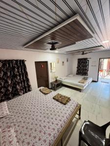 a bedroom with two beds and a ceiling at Shree Savali Cottage in Revadanda