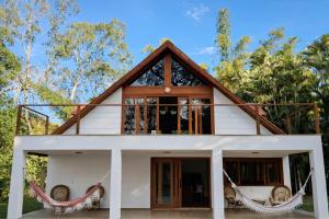 a guest house with a wrap around porch at Chalé Pedra Furada in Resende