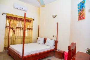 a bedroom with a bed with white sheets and a window at Hotel Résidence Les Racines in Pira +8 photos