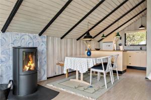 a living room with a table and a fireplace at 0161-Romo-Ejnar-Mikkelsensvej-4 in Høm +13 photos
