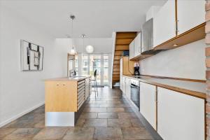 a kitchen with white cabinets and a tile floor at 1170-Romo-Gulirisvej-170 in Høm