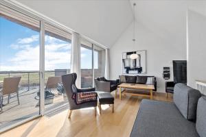 a living room filled with furniture and a large window at 1170-Romo-Gulirisvej-170 in Høm