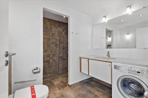 a bathroom with a washing machine and a sink at 1170-Romo-Gulirisvej-170 in Høm +13 photos