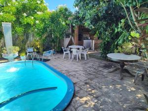 a backyard with a swimming pool and a table and chairs at Só Alegria in Paulista