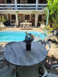a table with flowers on it next to a pool at Só Alegria in Paulista