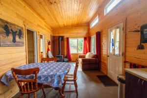 a room with a table and chairs in a cabin at Espace des Grands-Ducs - Domaine de Lacs et de forêt in Sacré-Coeur-Saguenay