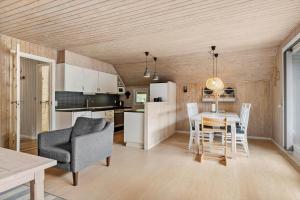 a kitchen and living room with a table and a chair at 0019-Romo-Moritzvej-12 in Høm