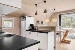 a kitchen with white cabinets and a black counter top at 0019-Romo-Moritzvej-12 in Høm +14 photos