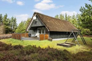 a house with a thatched roof and a swing at 0019-Romo-Moritzvej-12 in Høm