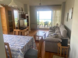 a living room with a couch and a table at apartamentos beach langosteira 2 in Finisterre