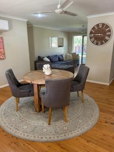 a living room with a table and chairs and a couch at Lamington Cottage in The Range +8 photos