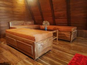 a room with two benches and a table in a cabin at Velya cabana in Belihuloya