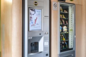 une machine à atm avec une photo d'une femme dans l'établissement B&B HOTEL Nantes Parc Expos La Chapelle, à La Chapelle-sur-Erdre