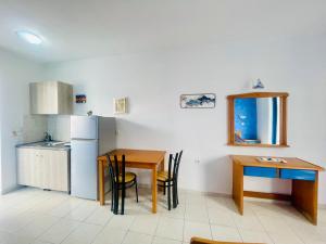 a small kitchen with a table and a refrigerator at Dodekanisos Studios in Faliraki