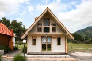 a small house with a red roof at Pousada Rural Pavão - Suites e Chalés in Urubici